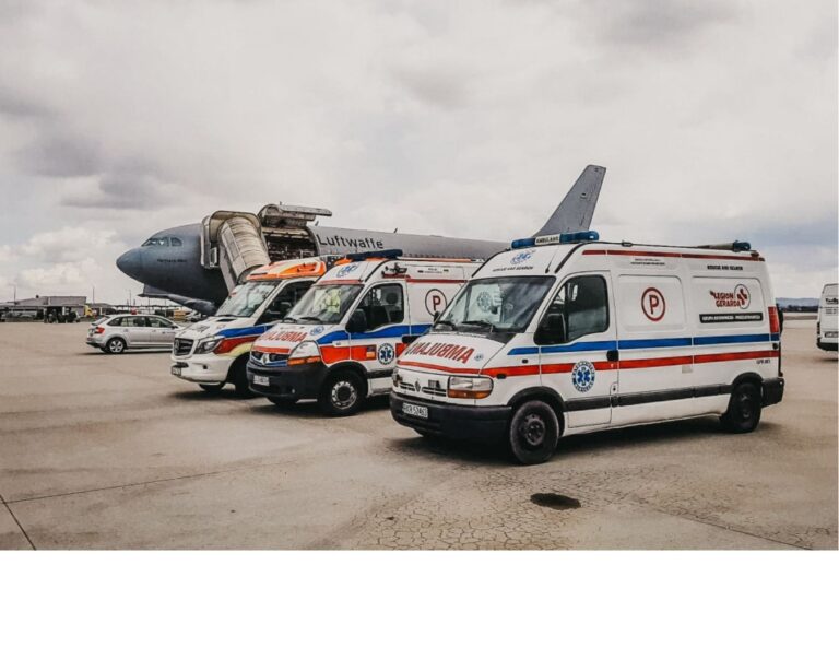 Ambulanse zespołów ewakuacyjnych przy samolocie transportowym na lotnisku