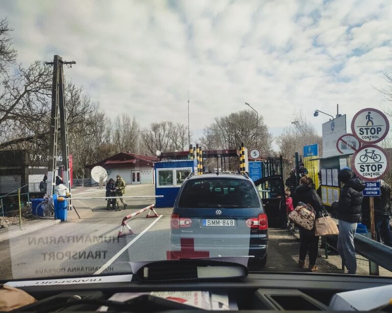 Samochód z oznaczeniem transportu humanitarnego przed szlabanem przejścia granicznego