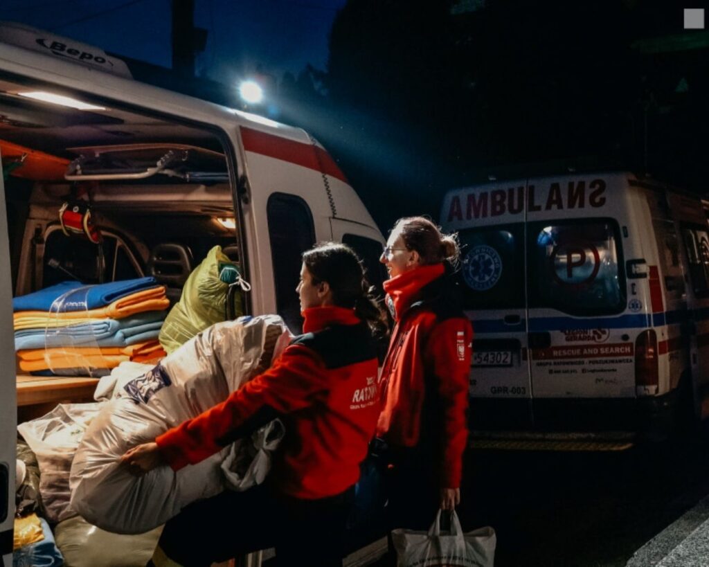 Ratowniczki przekładają koce i śpiwory z ambulansu nocą