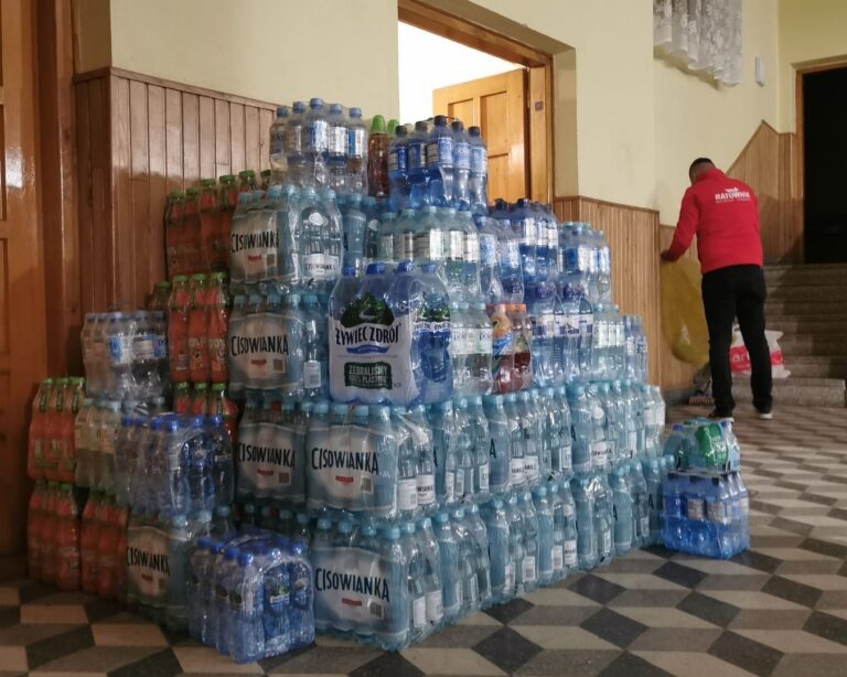 Zgrzewki wody butelkowanej ułożone w magazynie darów