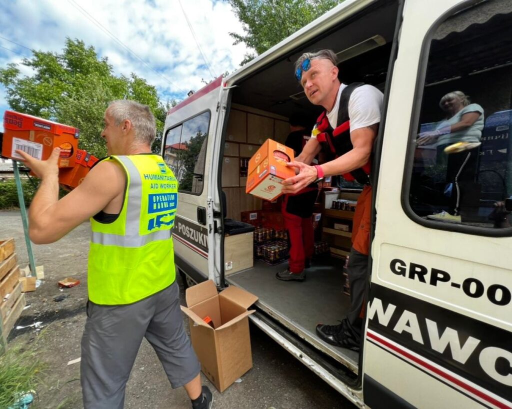Rozładunek kartonów z ambulansu grupy ratowniczo-poszukiwawczej podczas misji humanitarnej