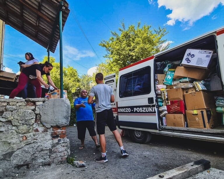 Rozładunek darów z samochodu przy budynku magazynowym