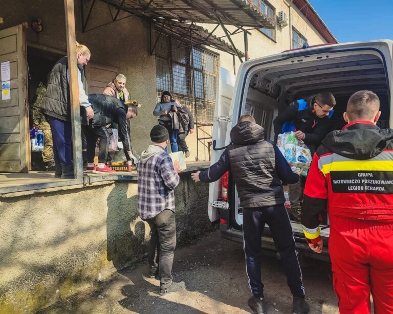 Przekazywanie darów z samochodu przy rampie budynku magazynowego