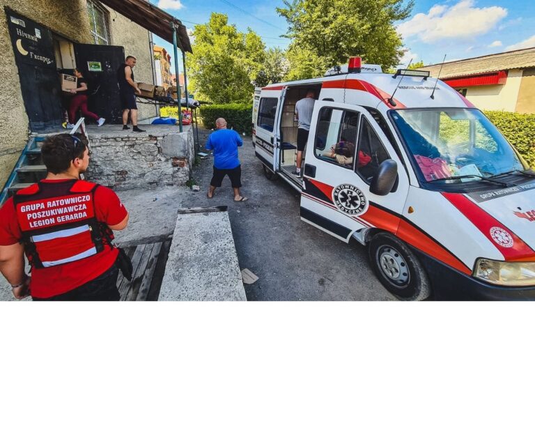 Ambulans z otwartymi drzwiami podczas przekazywania pomocy